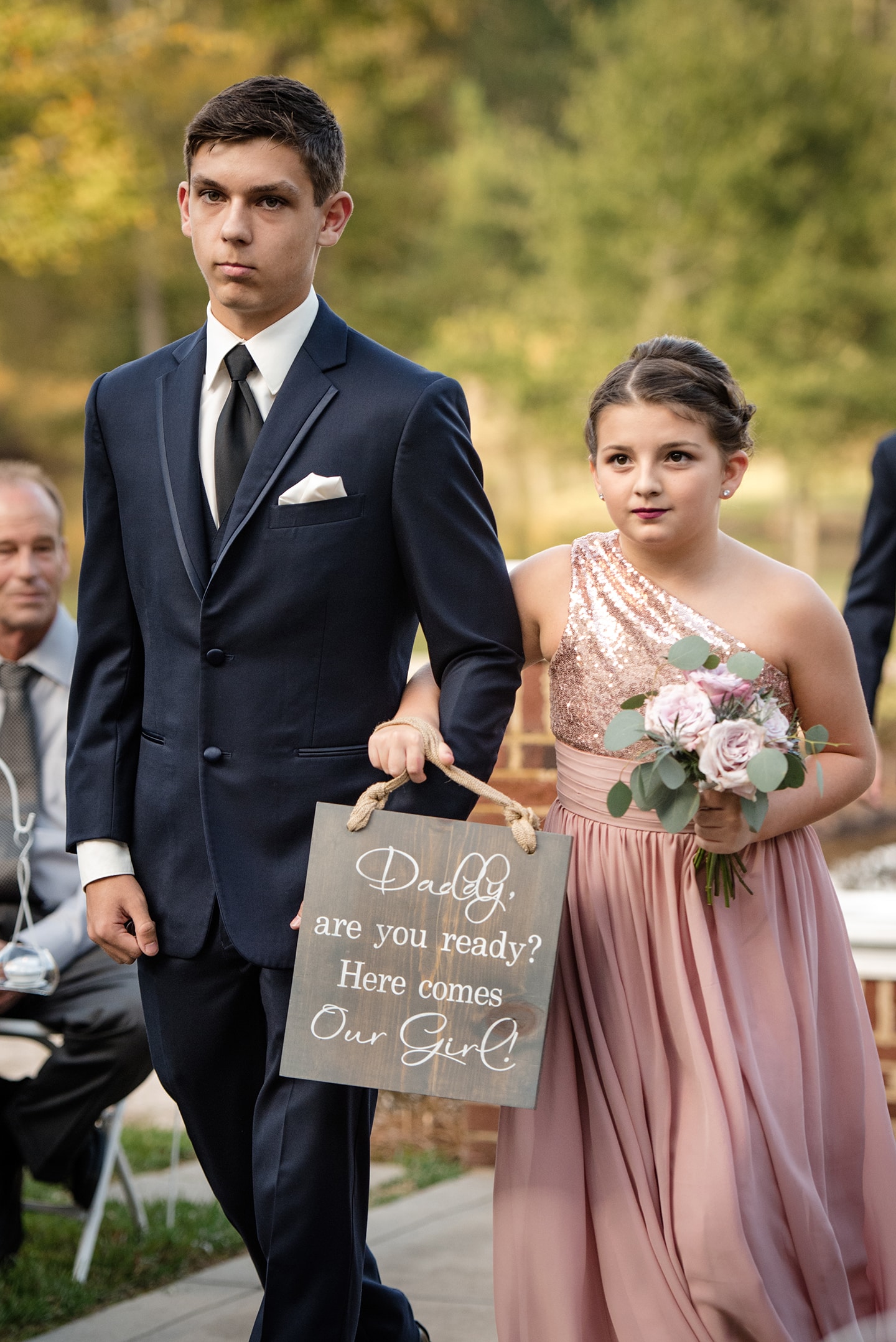 Children at wedding ceremony carrying wedding sign