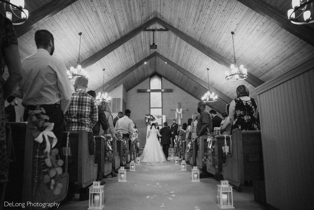 Low wide shot of wedding ceremony at Rock Christian Church of Concord by Charlotte Wedding Photographers DeLong Photography