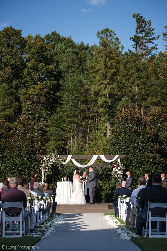 A photograph of an outdoor wedding ceremony at Sweet Magnolia Estate by Charlotte Wedding Photographers DeLong Photography