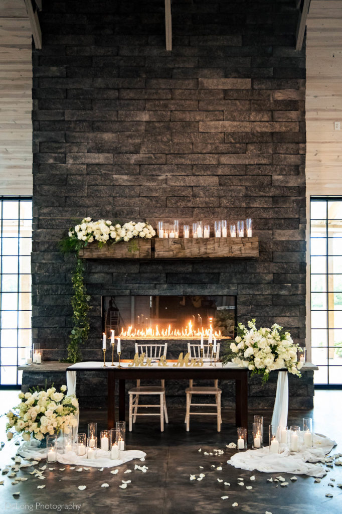 Photograph of sweetheart table in front of the fireplace at Board in Batten in Lexington, NC by Charlotte Wedding Photographers DeLong Photography