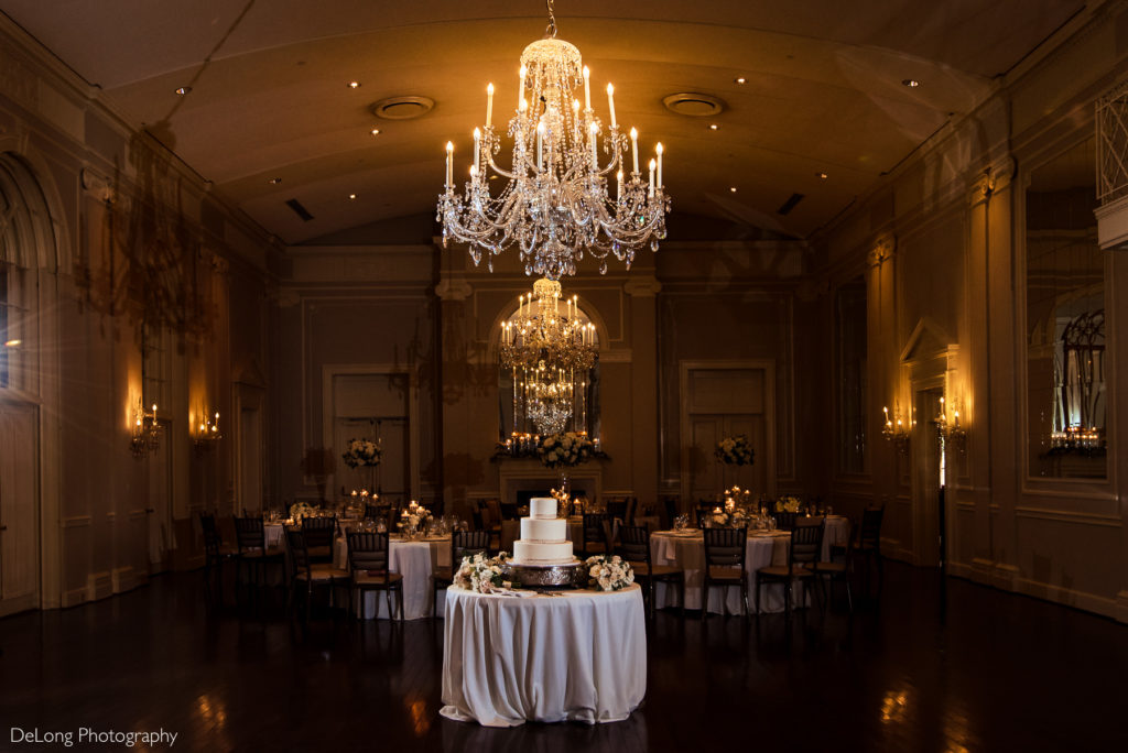 Wedding cake and decor in main ballroom during a wedding reception by Charlotte Wedding Photographers DeLong Photography