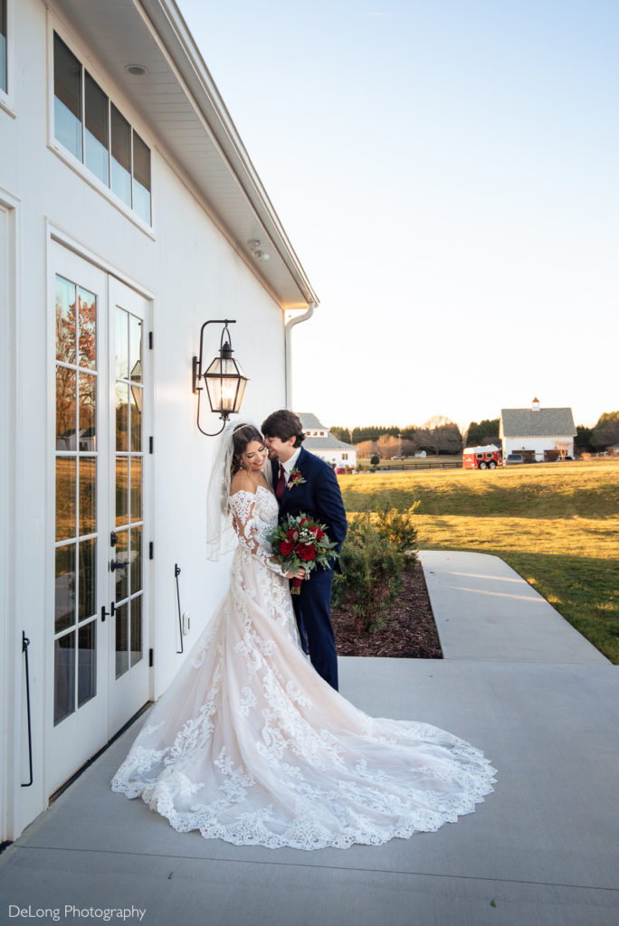 Portrait of Groom nuzzling into bride's cheek smiling outside the chapel at Chickadee Hill Farms by Charlotte Wedding Photographers DeLong Photography