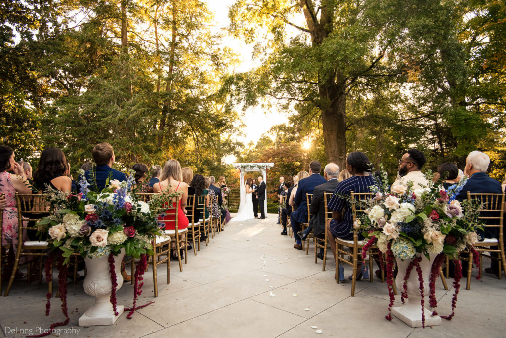 Bride and groom sharing wedding vows during sunset wedding ceremony at VanLandringham Estate by Charlotte Wedding Photographers DeLong Photography
