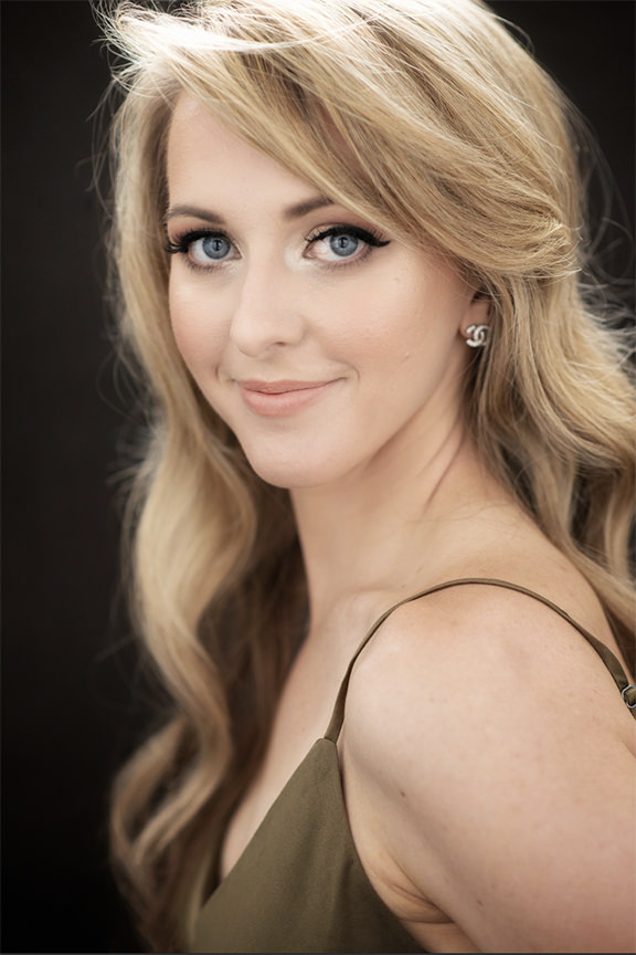 Headshot of Shannon DeLong of DeLong Photography, a Charlotte, NC based wedding photographer, in olive green cami on a black background