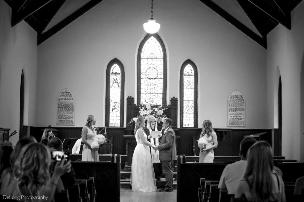 Bride and groom saying vows at altar in St. Mary's Chapel by Charlotte Wedding Photographers DeLong Photography