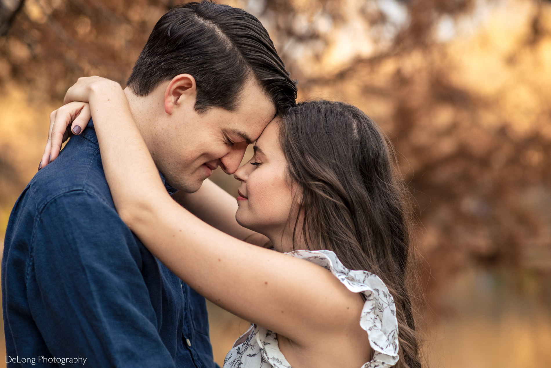 Close up photograph of an engaged couple nuzzling with foreheads together at Freedom Park by Charlotte wedding photographers DeLong Photography