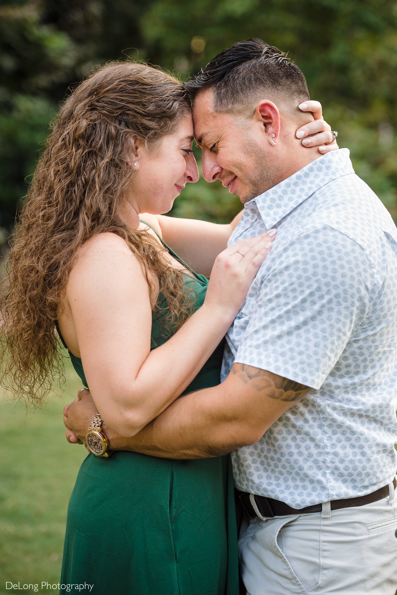 Couple forehead-to-forehead enjoying a sweet moment during a Romare Bearden Park engagement session by Charlotte wedding photographers DeLong Photography