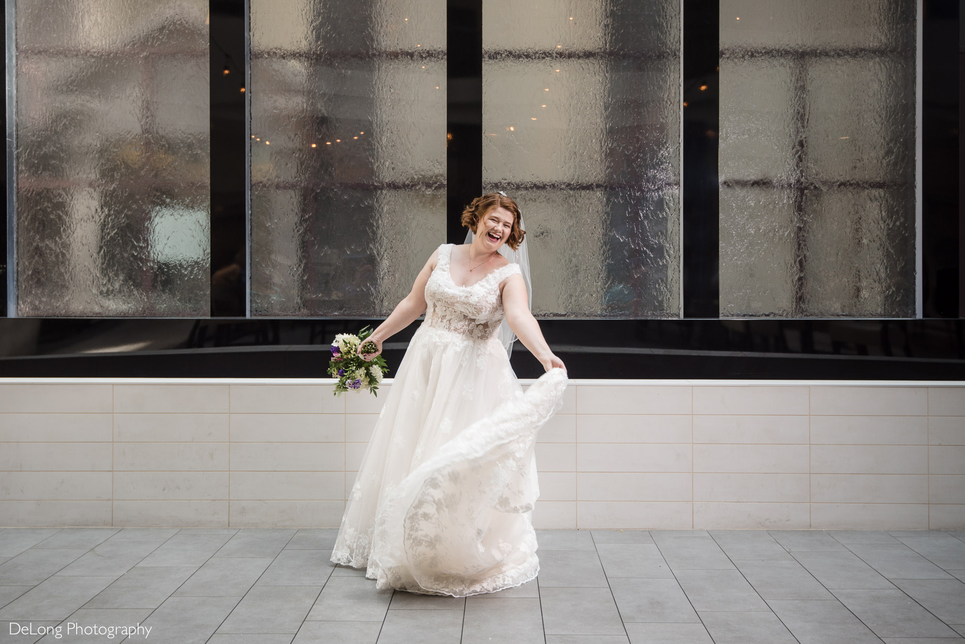 Fun bridal portrait in atrium of Embassy Suites by Hilton Charlotte by Charlotte wedding photographers DeLong Photography
