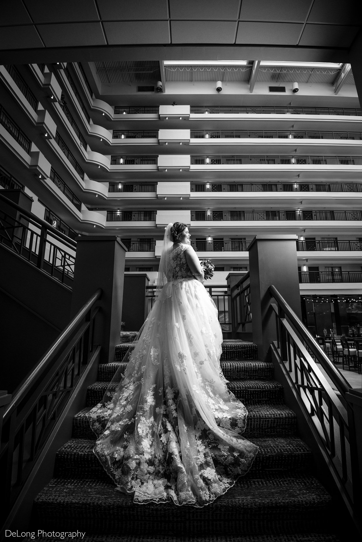 Black and white bridal portrait on staircase of Embassy Suites by Hilton Charlotte by Charlotte wedding photographers DeLong Photography