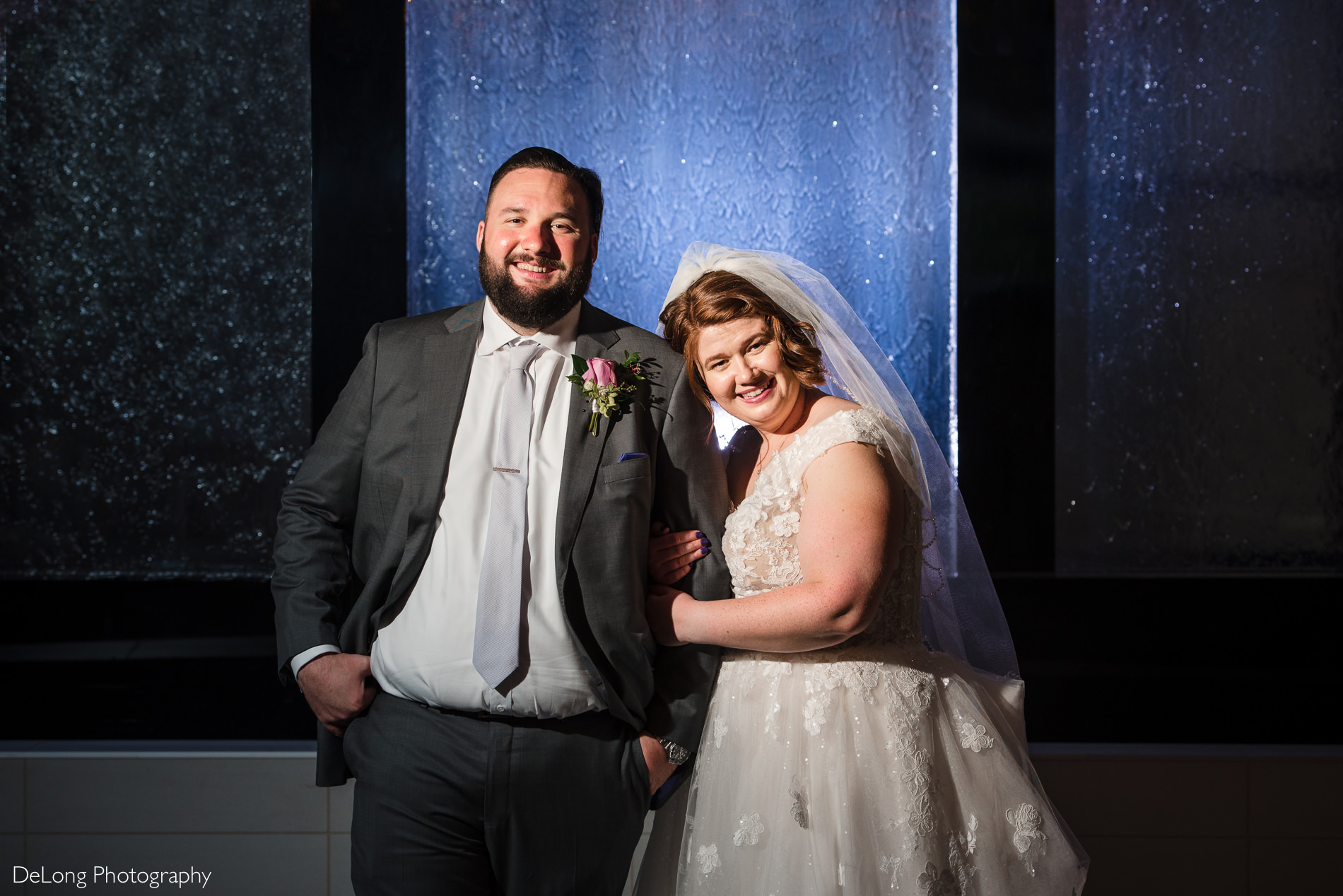 Bride and groom portrait in front of water feature at the Embassy Suites by Hilton Charlotte by Charlotte wedding photographers DeLong Photography