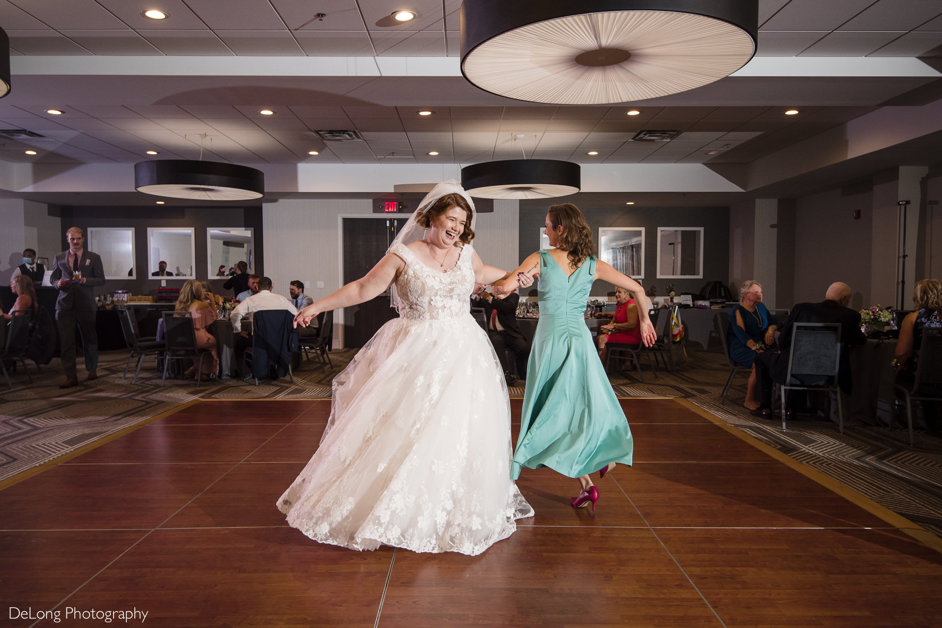 Bride having fun dancing at the Embassy Suites by Hilton Charlotte by Charlotte wedding photographers DeLong Photography