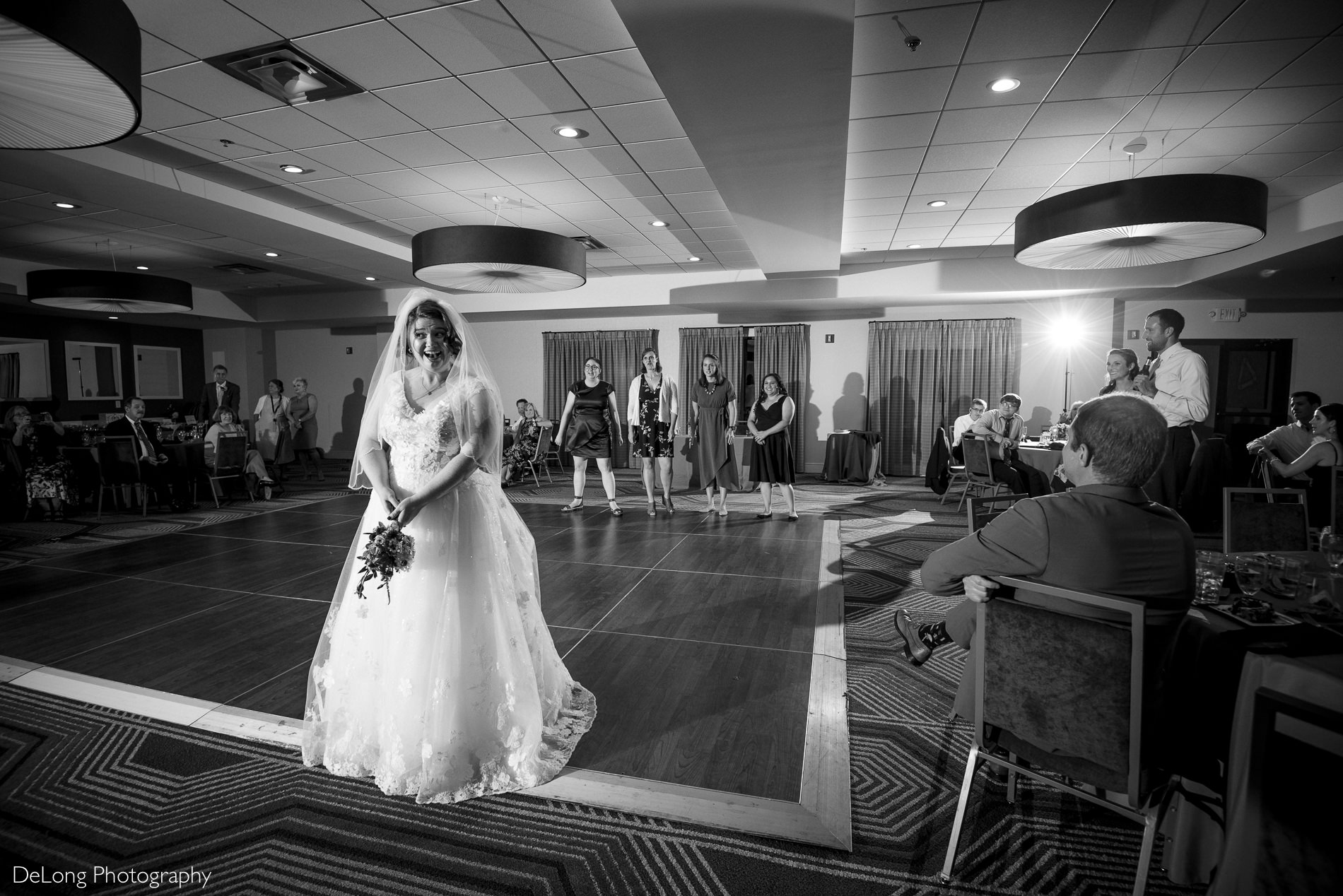 Black and white image of bride preparing for bouquet toss the Embassy Suites by Hilton Charlotte by Charlotte wedding photographers DeLong Photography