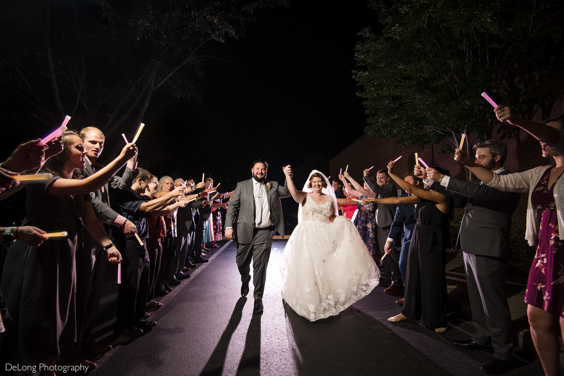 Bride and groom faux exit with glow sticks at the Embassy Suites by Hilton Charlotte by Charlotte wedding photographers DeLong Photography