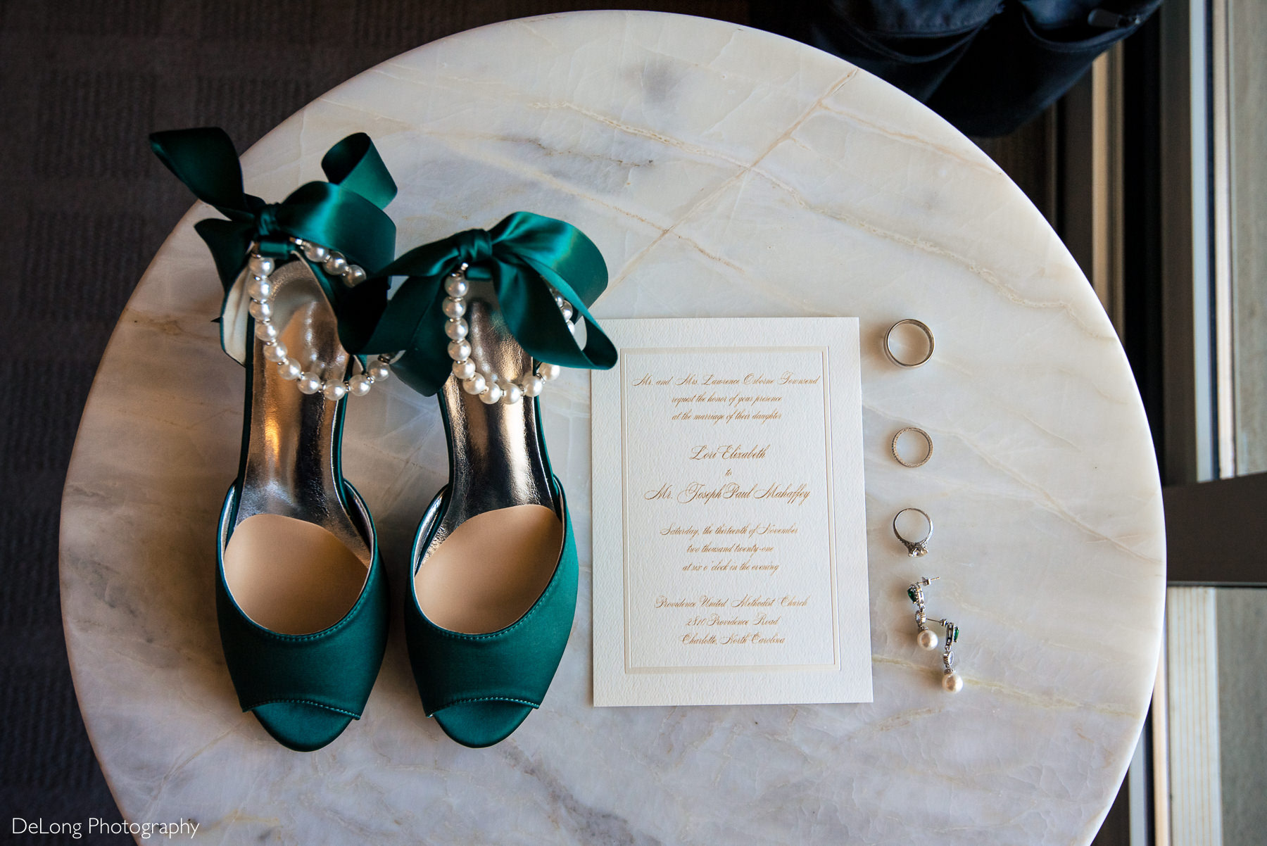 Green wedding shoes with bead anklet on marble table with wedding invitation, wedding tings, and the bride's earrings by Charlotte Wedding Photographers DeLong Photography