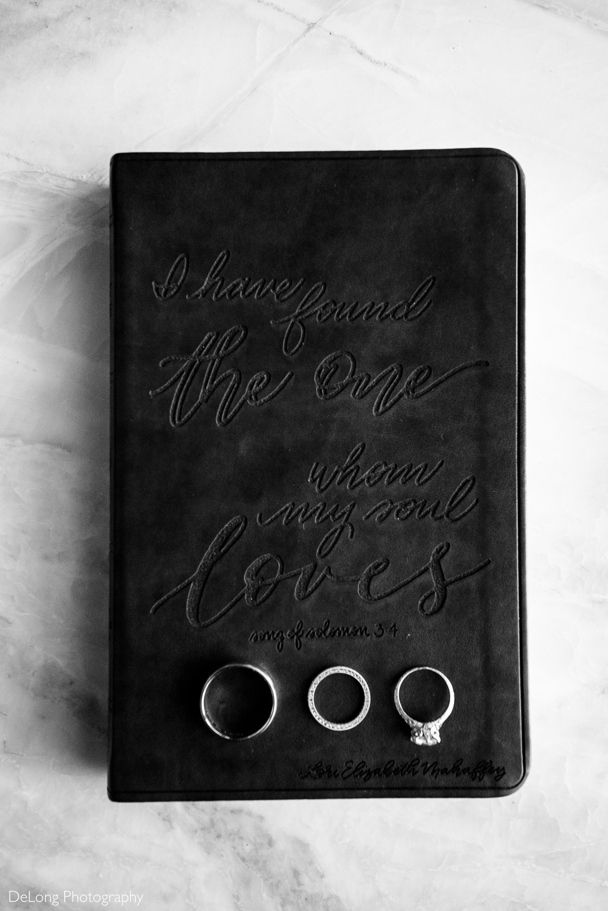 Bible with etching that says "I have found the one whom my soul loves"with wedding rings by Charlotte Wedding Photographers DeLong Photography