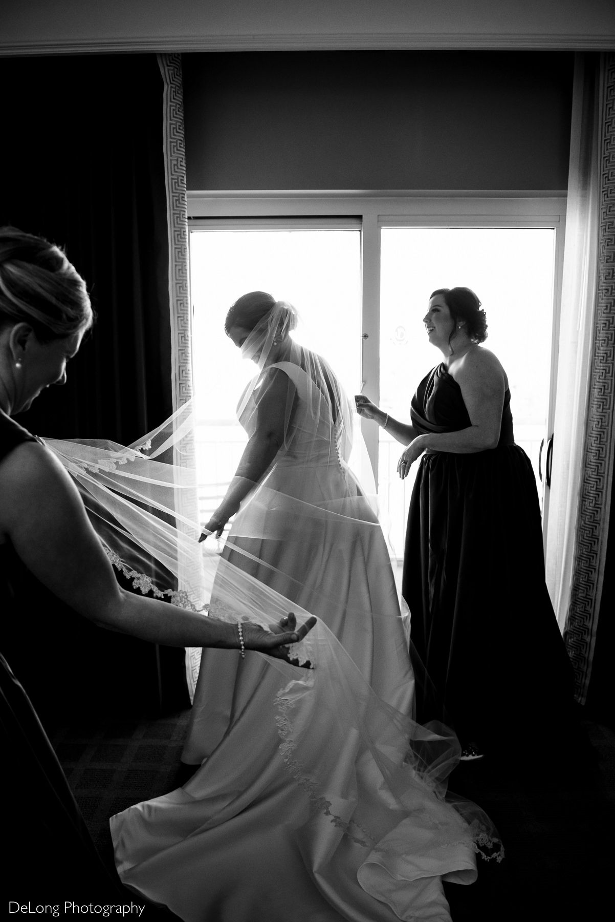 Matrons of Honor helping bride with her veil and checking her hair by Charlotte Wedding Photographers DeLong Photography