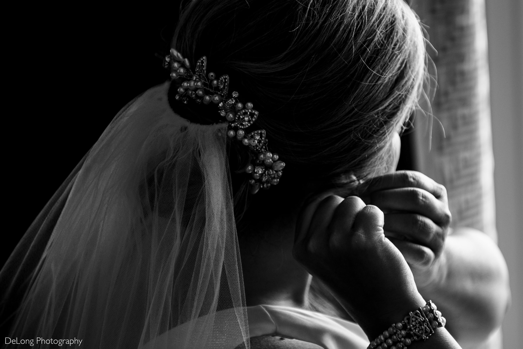Close detail shot of hairpiece as bride is putting in her earrings by Charlotte Wedding Photographers DeLong Photography