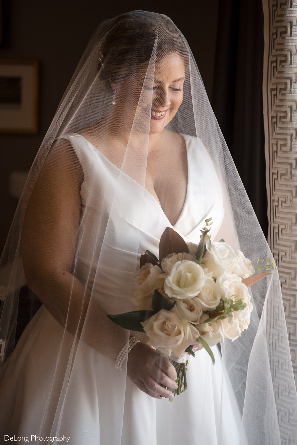 Bridal portrait with the veil cascading down over her face by Charlotte Wedding Photographers DeLong Photography