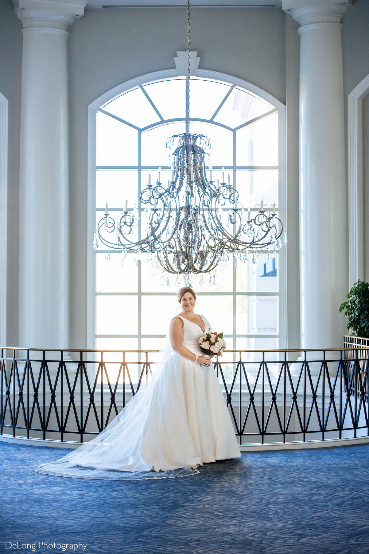 Bridal portrait in front of the chandelier at the Ballantyne Hotel by Charlotte Wedding Photographers DeLong Photography