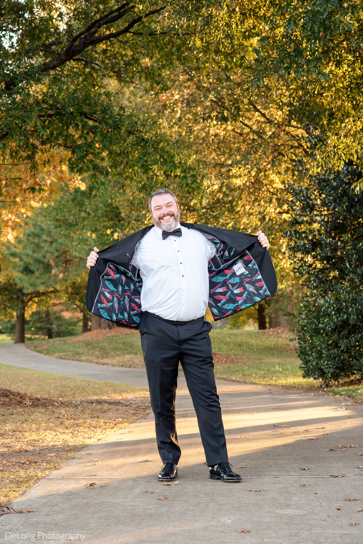 Groom showing off his custom suit jacket with fishing lures as the design by Charlotte Wedding Photographers DeLong Photography