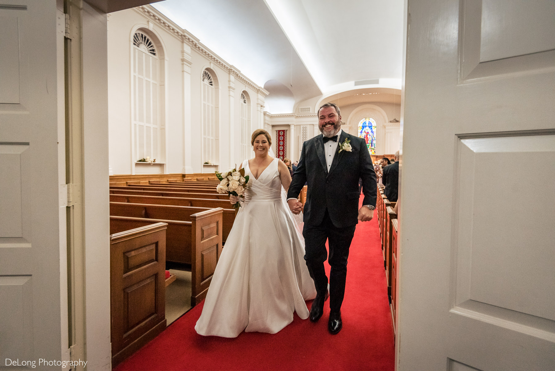 Bride and groom recessing down the aisle at Providence Methodist aisle by Charlotte Wedding Photographers DeLong Photography