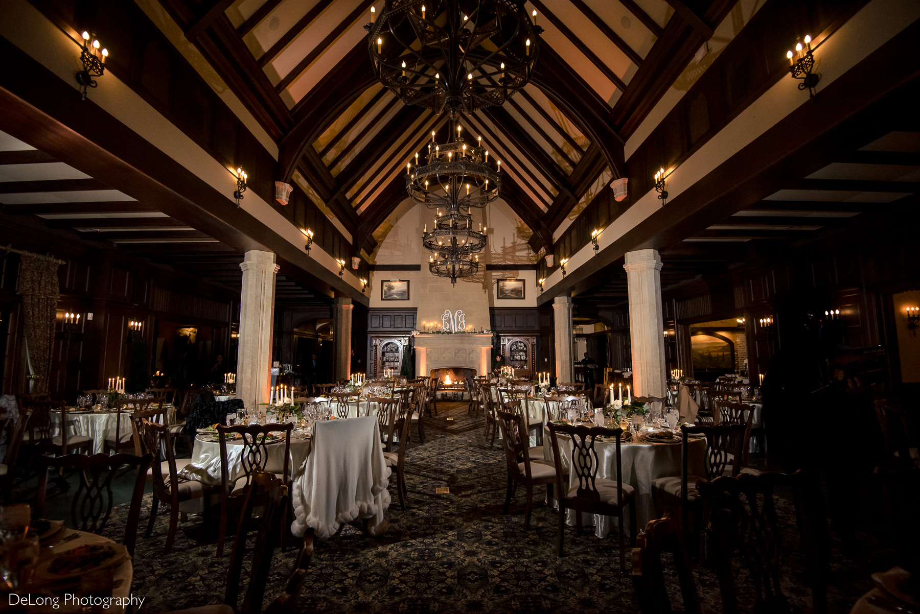 Wedding reception room at the Club at Longview with a lit fireplace and candles throughout by Charlotte Wedding Photographers DeLong Photography
