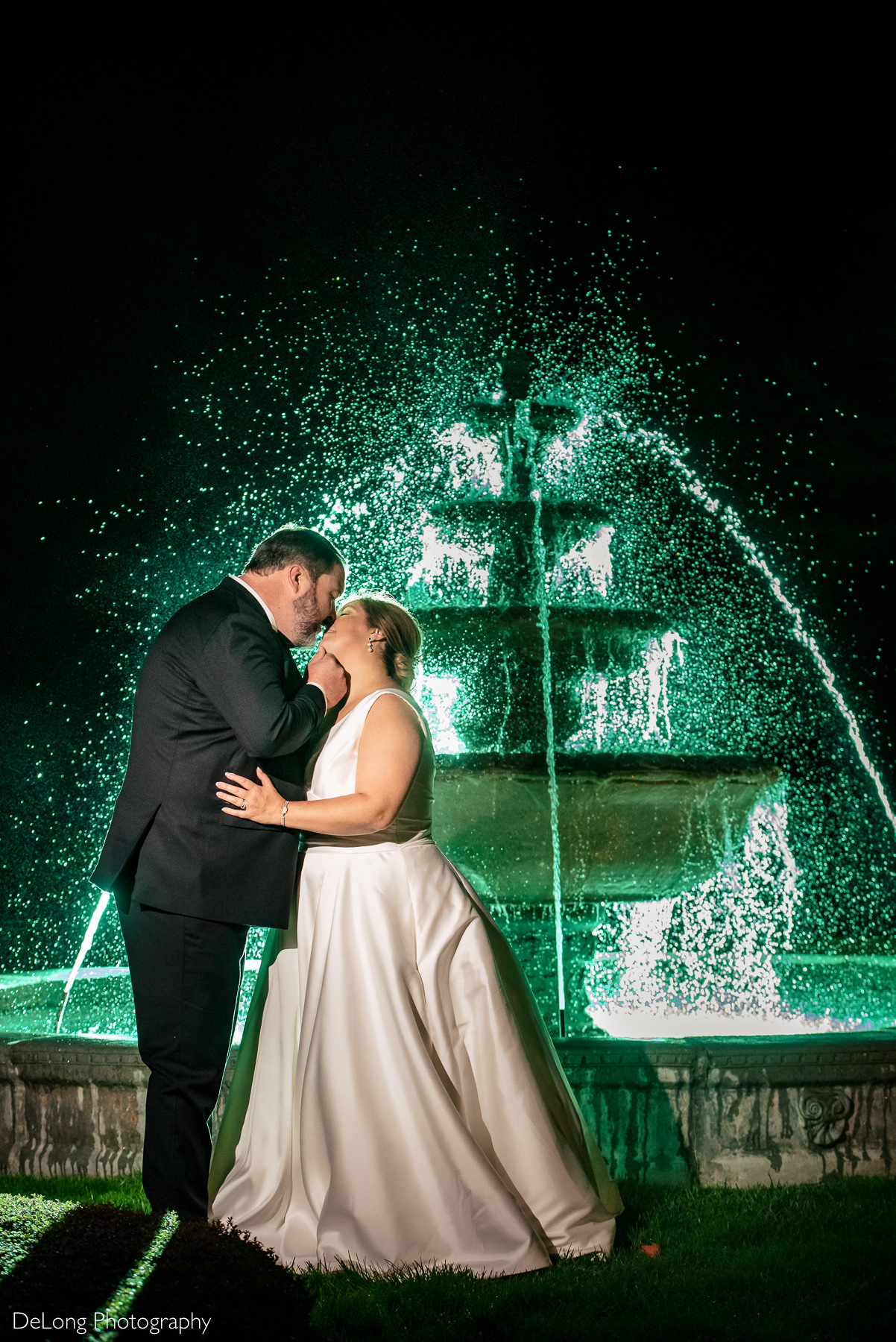 Bride and groom kissing night portrait in front of fountain at The Club at Longview wedding by Charlotte Wedding Photographers DeLong Photography
