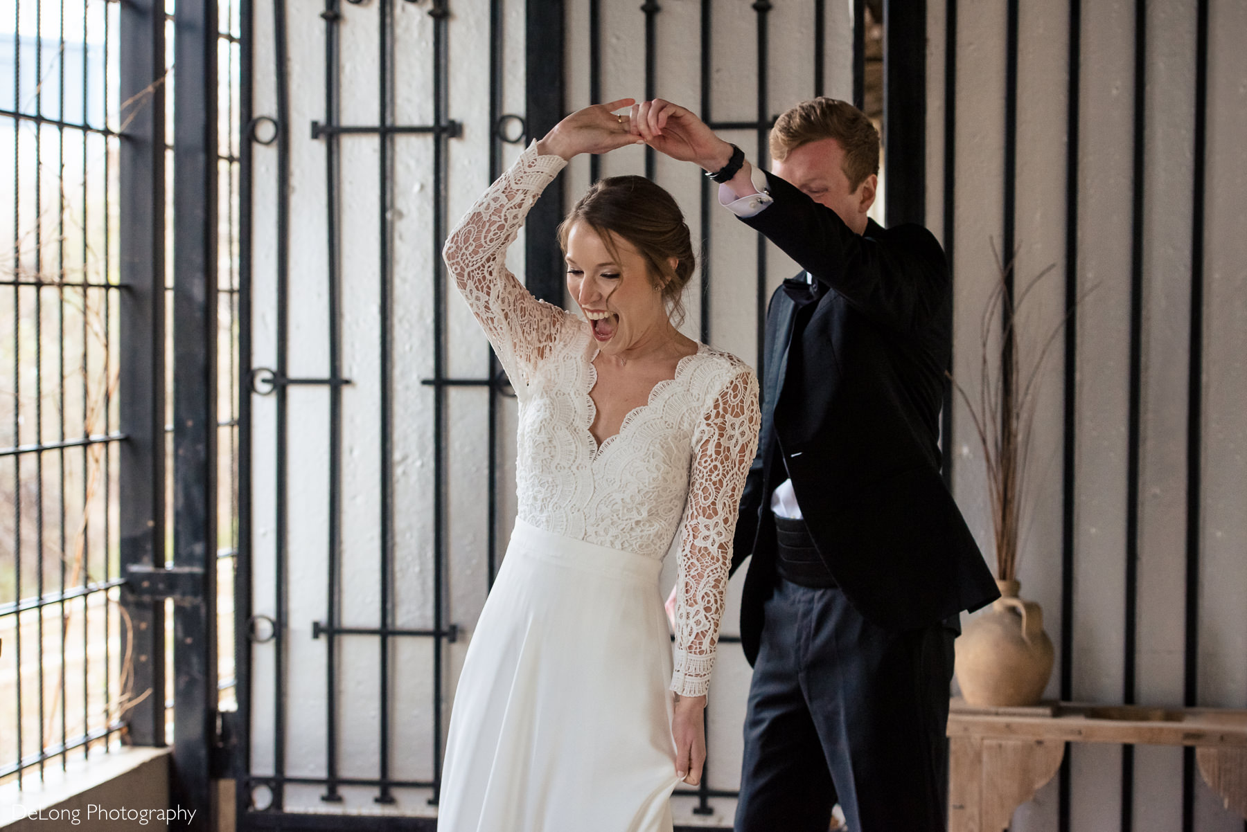 Groom twirling the bride during a first look at the Westside Warehouse in Atlanta by Charlotte wedding photographers DeLong Photography