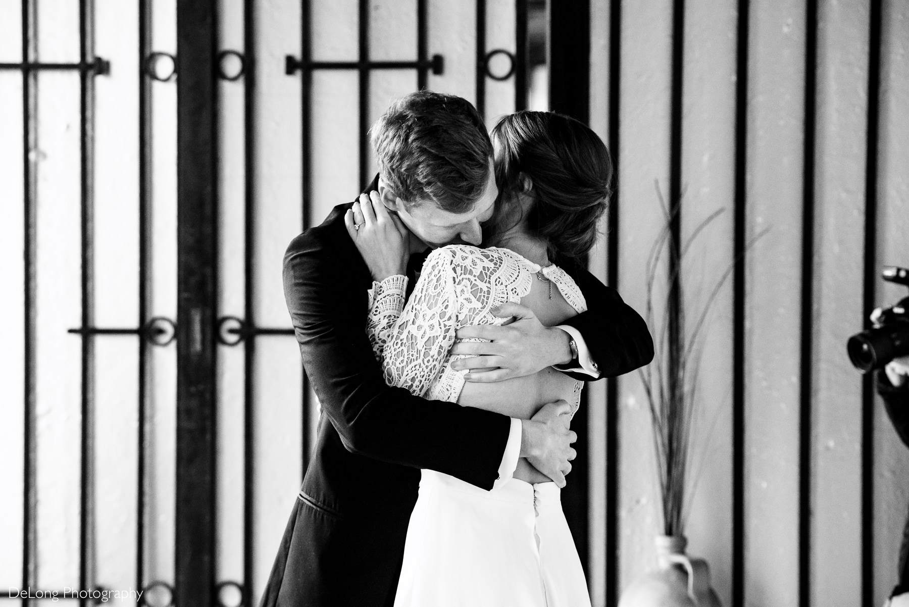 Black and white image of a bride and groom embracing during a first look at the Westside Warehouse in Atlanta by Charlotte wedding photographers DeLong Photography