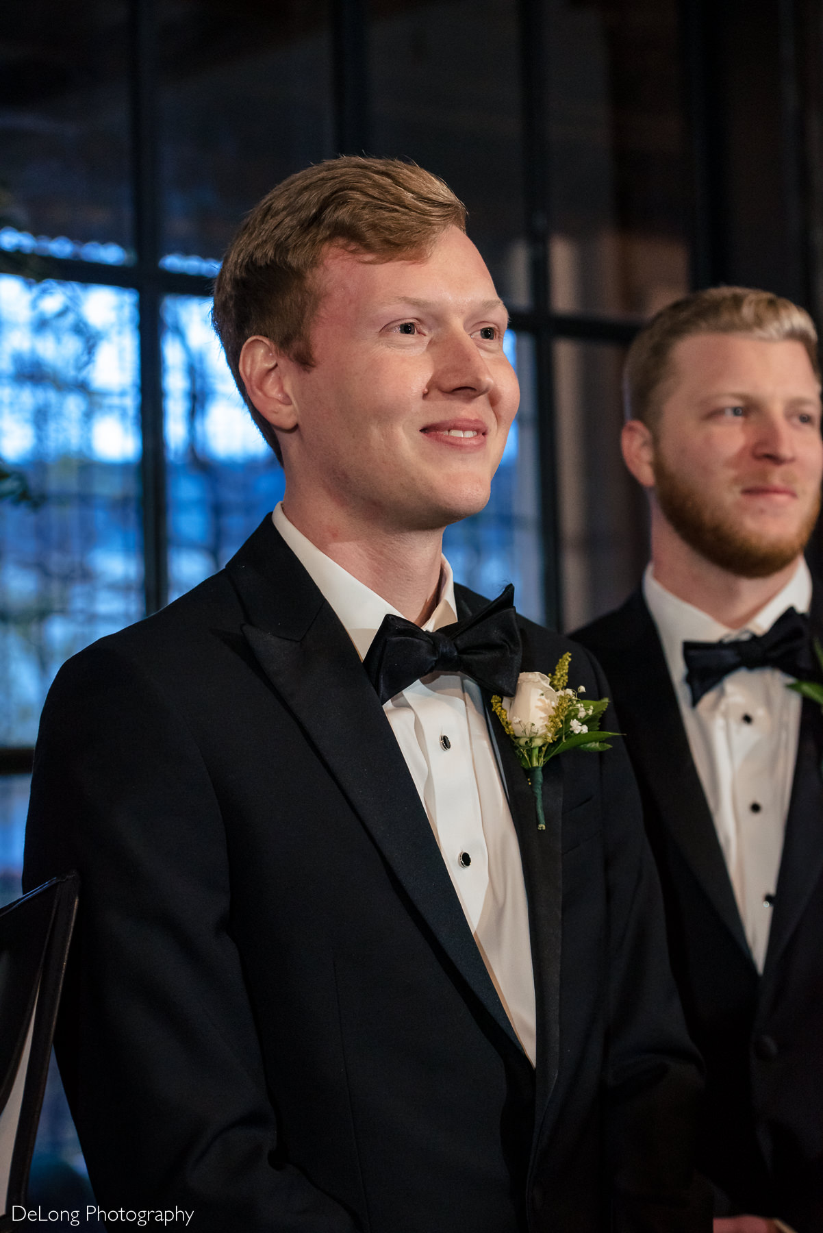 Groom smiling seeing his bride come down the aisle at the Westside Warehouse by Charlotte wedding photographers DeLong Photography
