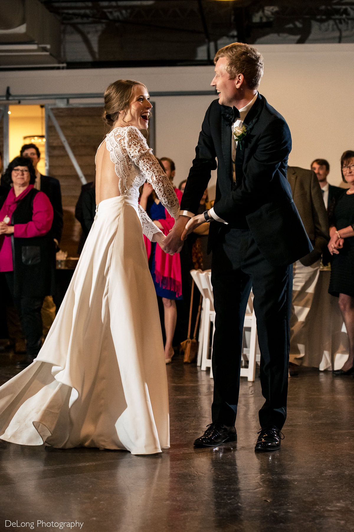 Bride and groom laughing and smiling during their fun choreographed first dance at the Westside warehouse in Atlanta by Charlotte wedding photographers DeLong Photography