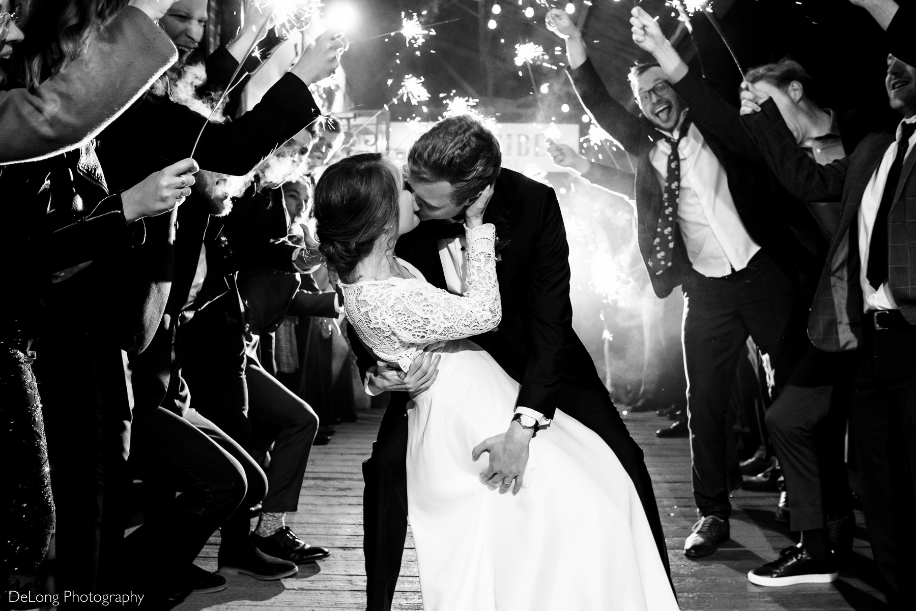 Black and white image of a groom dipping a bride during the sparkler exit at the Westside warehouse in Atlanta by Charlotte wedding photographers DeLong Photography
