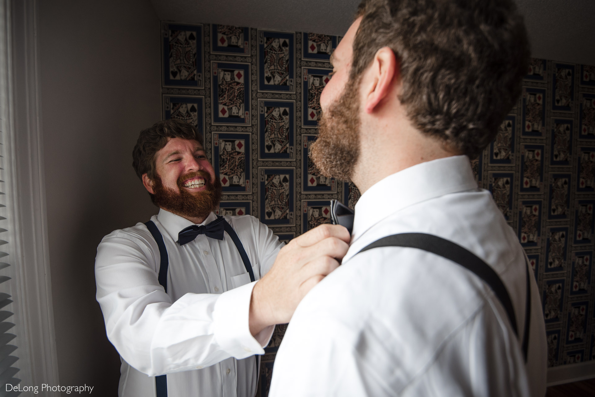 Brother helping put on tie of the groom at the Island house by Charlotte Wedding Photographers DeLong Photography