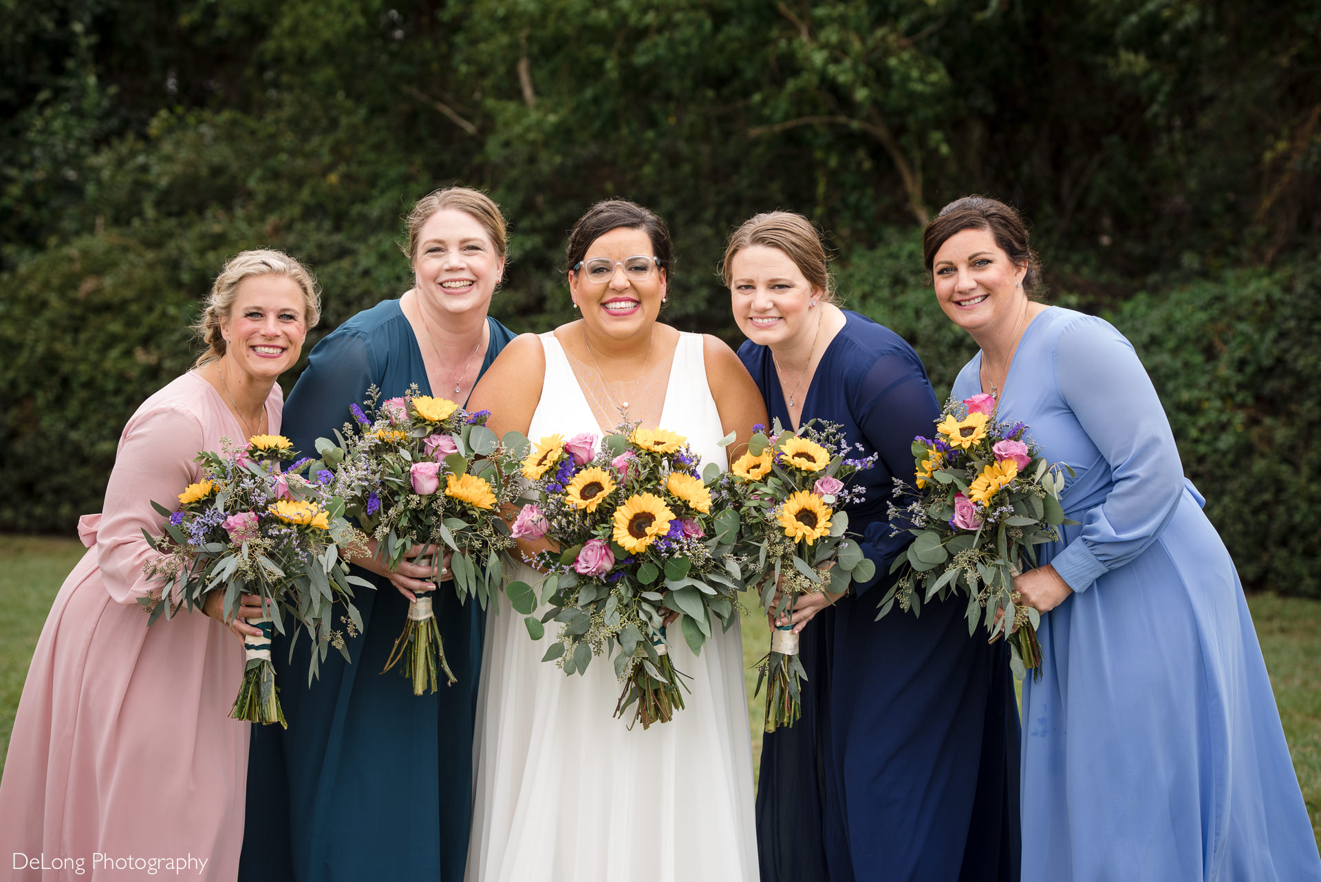 Bride and her bridesmaids holding colorful bouquets wearing colorful dresses at the Island House in Charleston, SC by Charlotte Wedding Photographers DeLong Photography