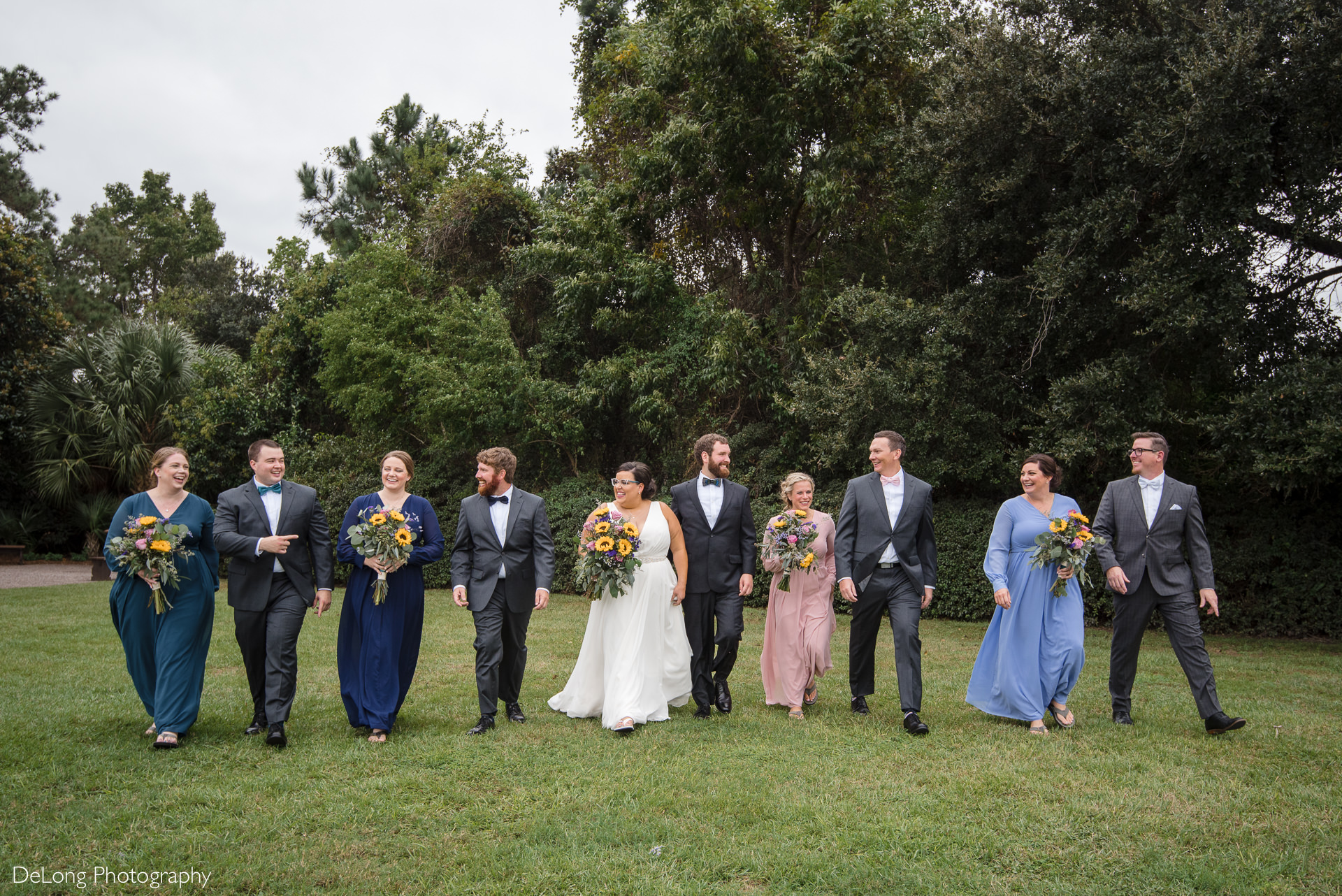 Wedding party walking and laughing on the lawn at the Island House in Charleston, SC by Charlotte Wedding Photographers DeLong Photography