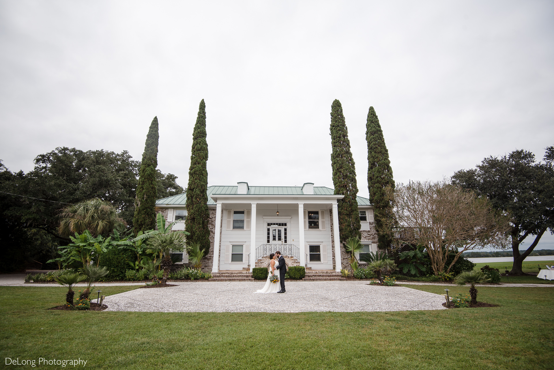 Bride and groom kissing in front of the house at the Island House in Charleston, SC by Charlotte Wedding Photographers DeLong Photography