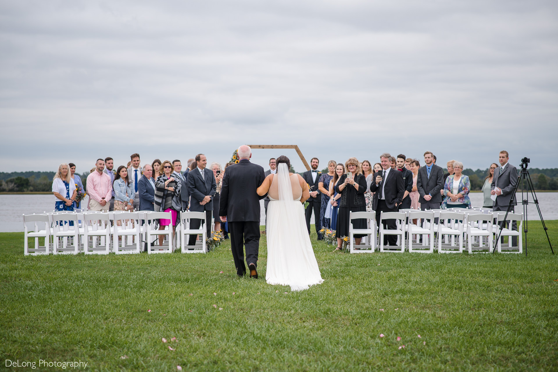 Ceremony image from behind as the bride is walked down the aisle at the Island House in Charleston, SC by Charlotte Wedding Photographers DeLong Photography