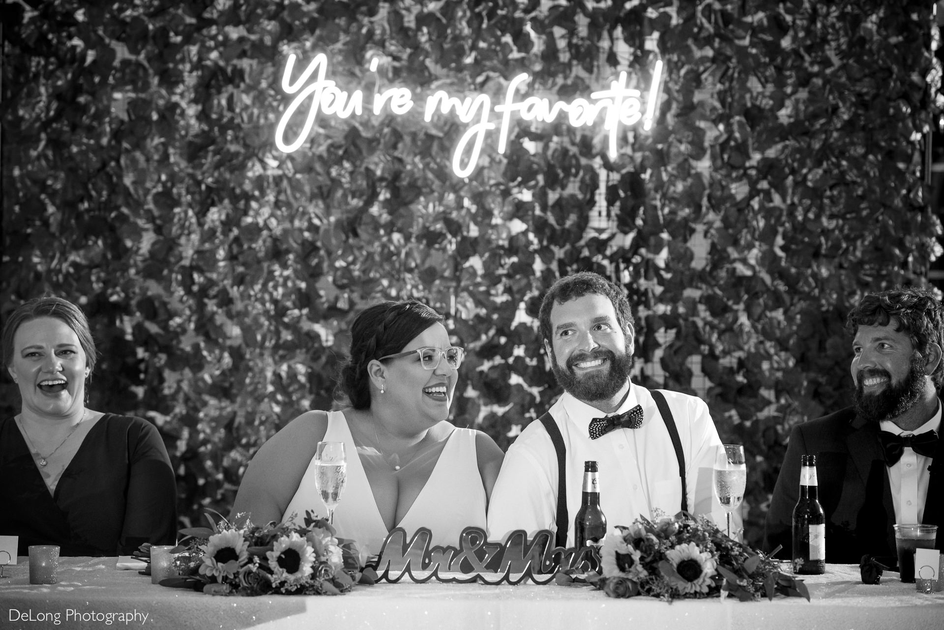 Black and white image of bride and groom laughing during a wedding toast at the Island House in Charleston, SC by Charlotte Wedding Photographers DeLong Photography