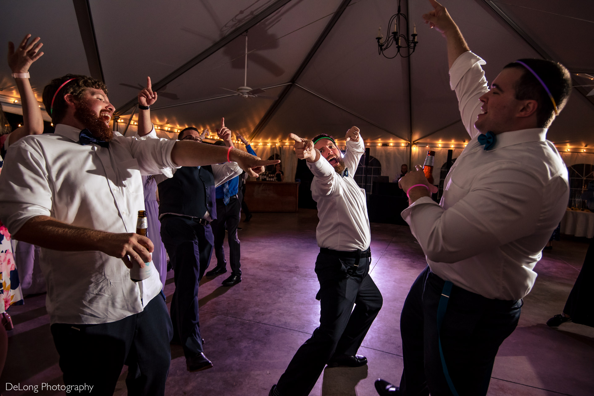 Groom and his groomsmen striking poses while singing with vigor during a wedding reception at the Island House in Charleston, SC by Charlotte Wedding Photographers DeLong Photography