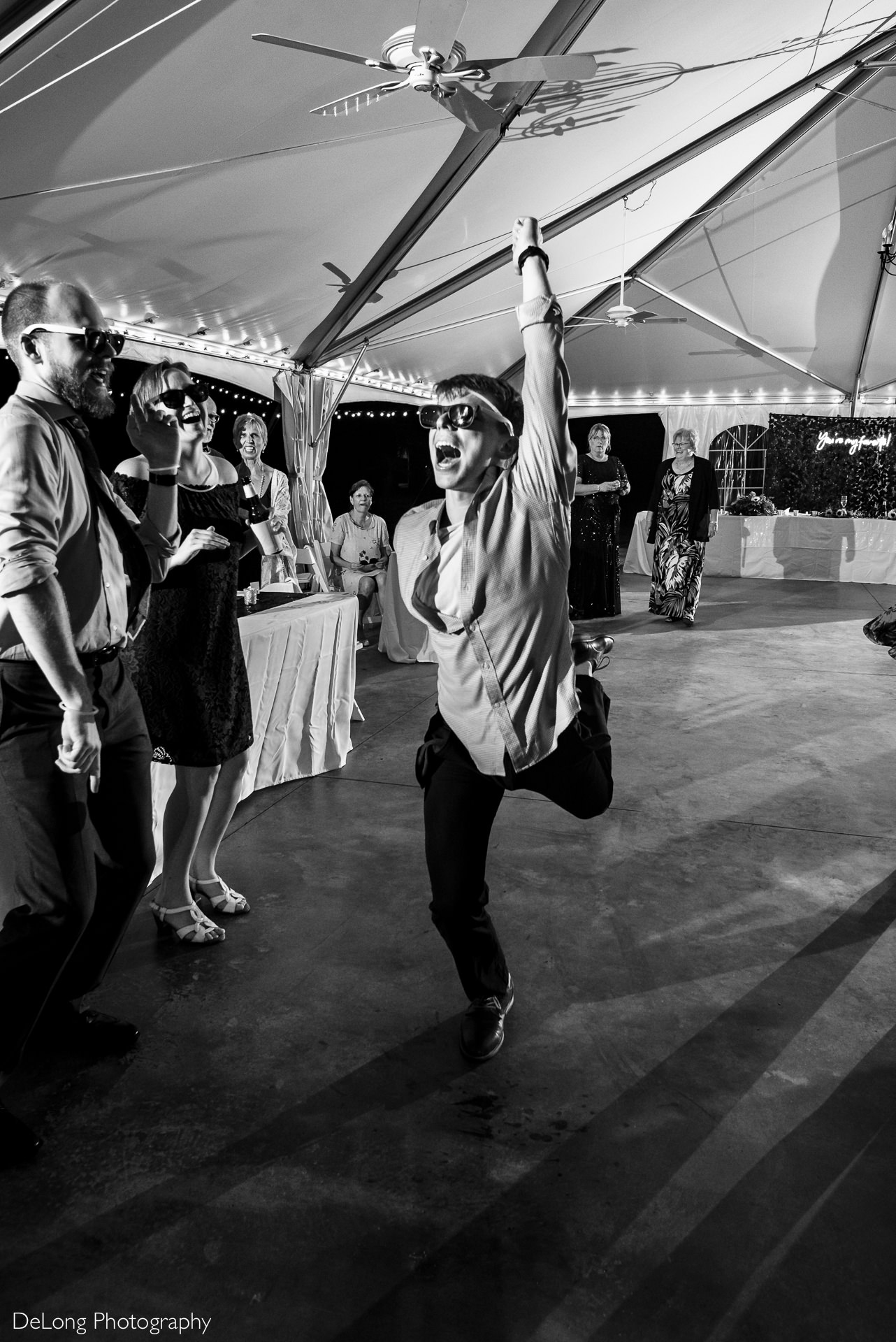 Wedding guest entertaining everyone by flailing his arms and legs while dancing at a wedding reception at the Island House in Charleston, SC by Charlotte Wedding Photographers DeLong Photography 