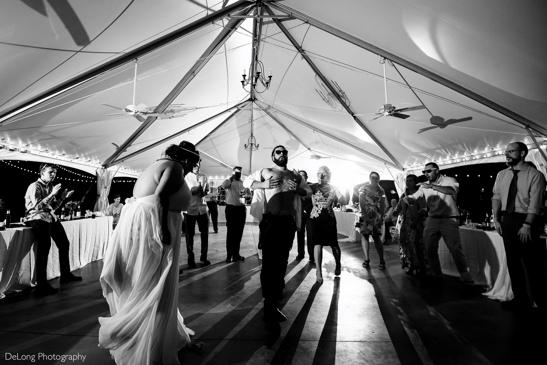 Groom holding his chest with his shirt undone on the dance floor at the Island House in Charleston, SC by Charlotte Wedding Photographers DeLong Photography