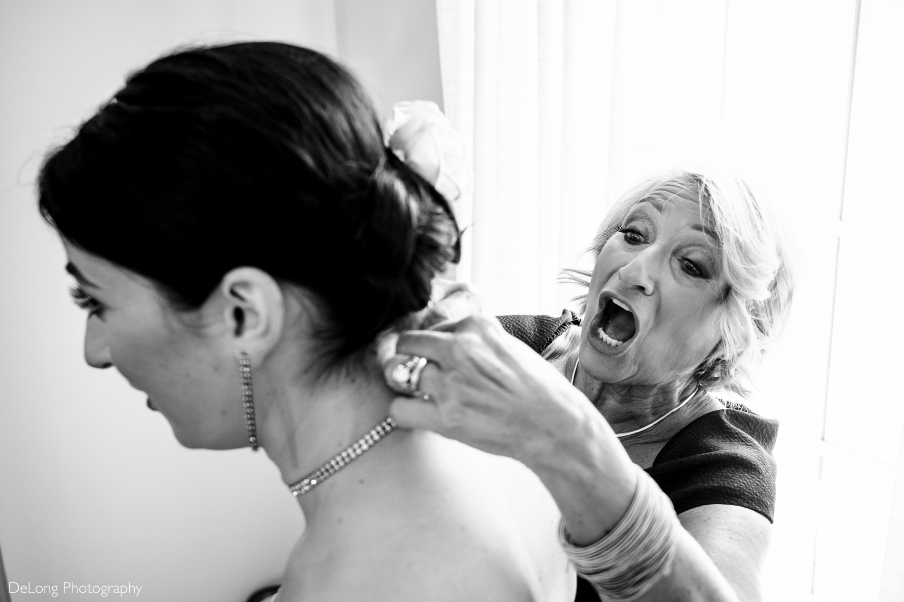 Black and white image of the Mother of the Bride helping put her necklace on at Childress Vineyards by Charlotte Wedding Photographers DeLong Photography