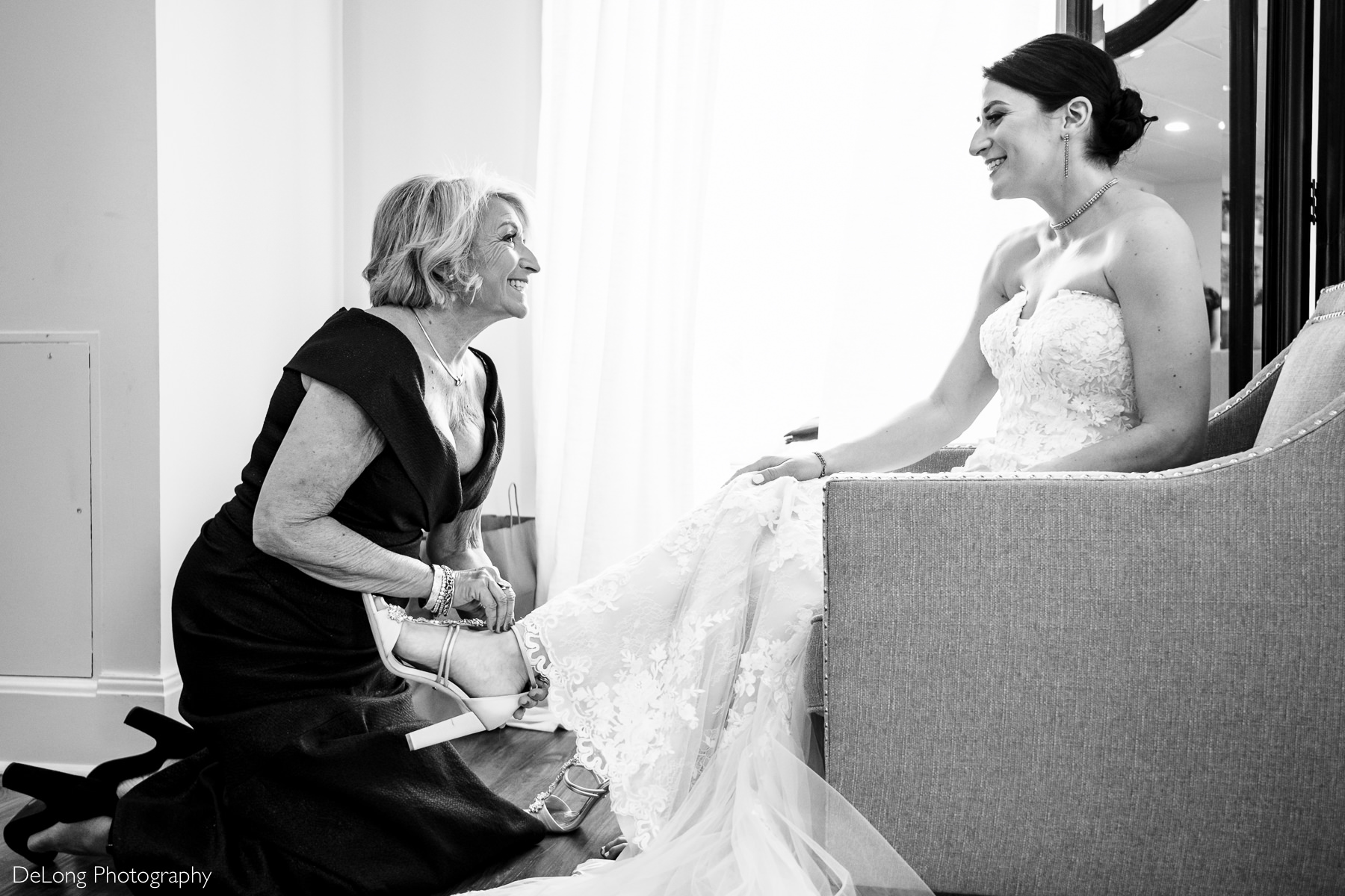 Black and white image of the Mother of the Bride helping put her shoes on at Childress Vineyards by Charlotte Wedding Photographers DeLong Photography
