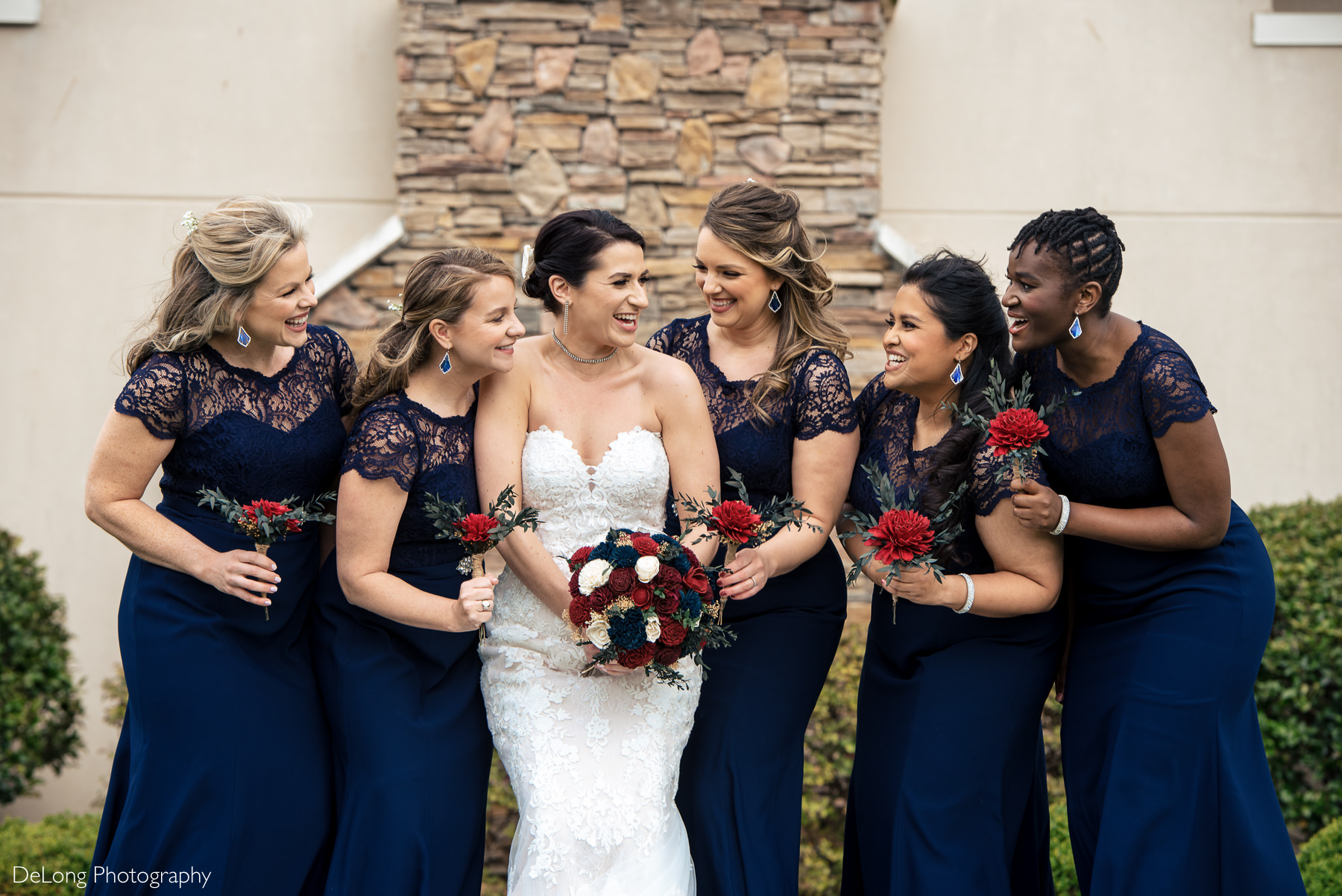 Bride with bridesmaids wearing navy dresses with red, white, and blue bouquets at Childress Vineyards by Charlotte Wedding Photographers DeLong Photography