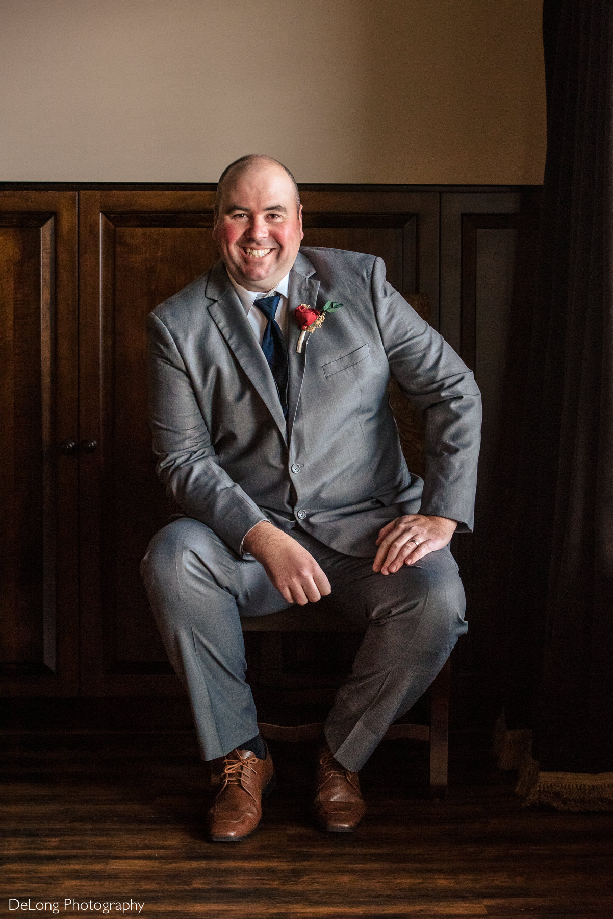 Seated portrait of groom in grooms suite at Childress Vineyards by Charlotte Wedding Photographers DeLong Photography
