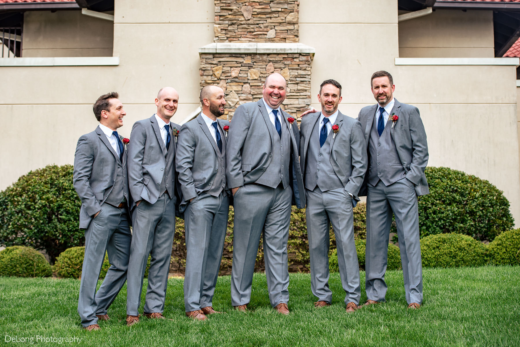 Portrait of groom with groomsmen laughing and hugging at Childress Vineyards by Charlotte Wedding Photographers DeLong Photography