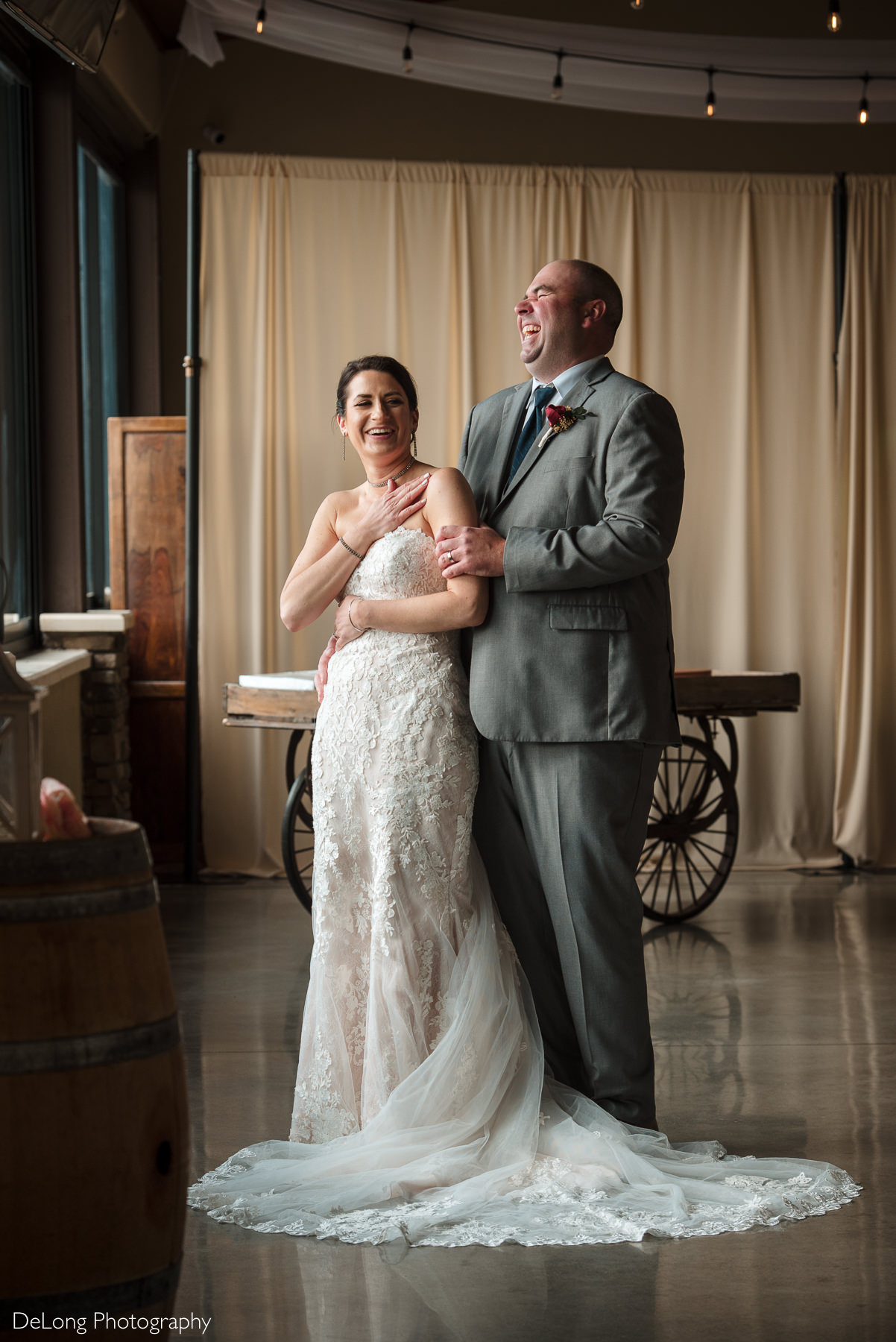 Bride and groom laughing during indoor portraits at Childress Vineyards by Charlotte Wedding Photographers DeLong Photography