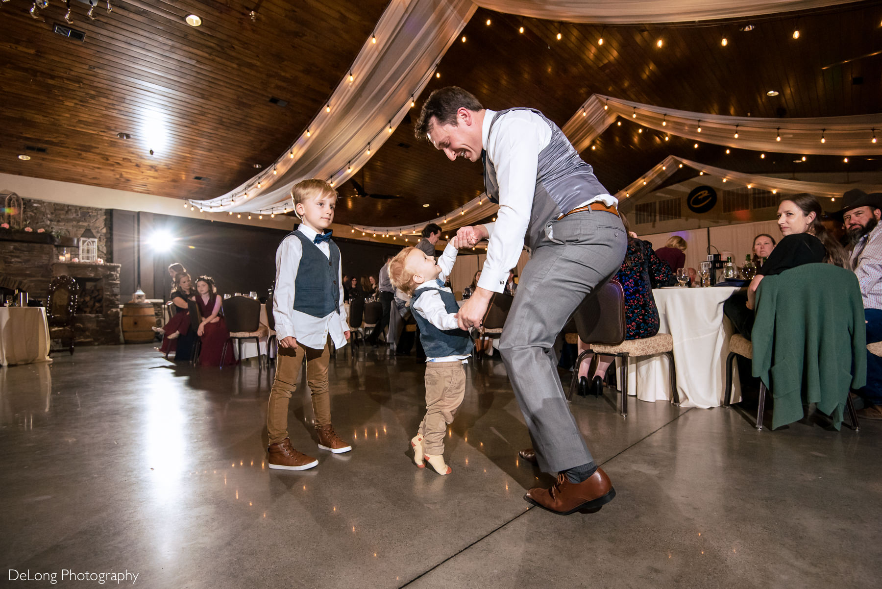 Man dancing with little boy during reception at Childress Vineyards by Charlotte Wedding Photographers DeLong Photography