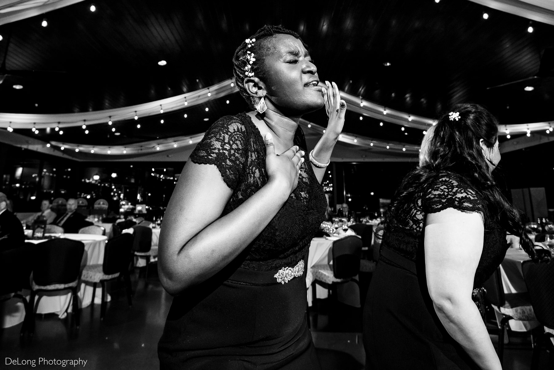 Black and white image of bridesmaid belting out song lyrics at the reception at Childress Vineyards by Charlotte Wedding Photographers DeLong Photography