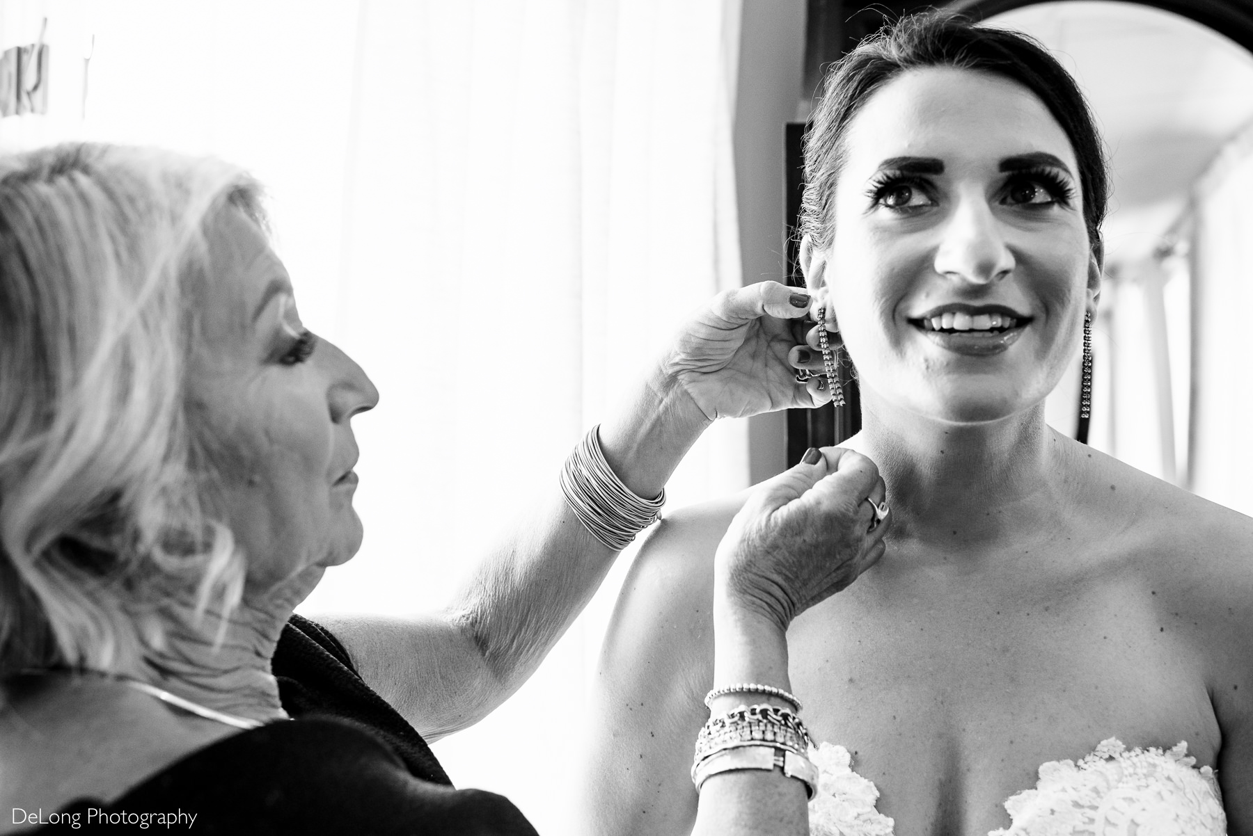 Black and white image of the Mother of the Bride helping put her earrings on at Childress Vineyards by Charlotte Wedding Photographers DeLong Photography